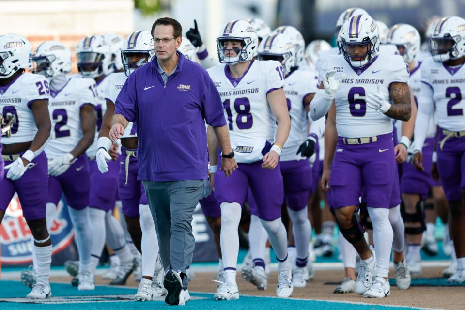 James Madison coach Curt Cignetti leads his team onto the field before their game against Coastal Carolina in Conway, S.C., Saturday, Nov. 25, 2023.