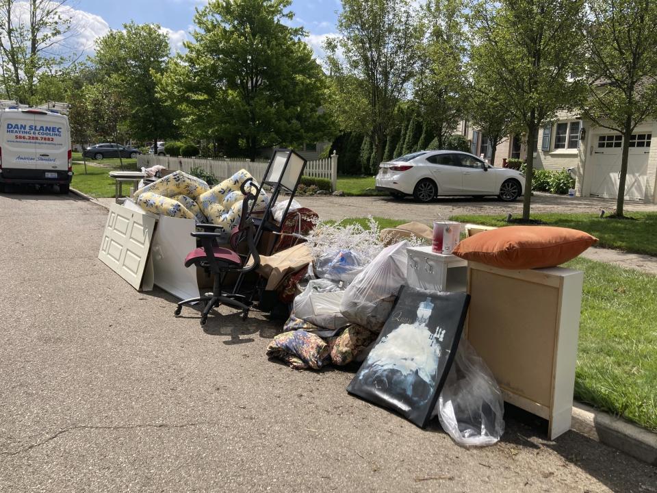 Trash is shown on a street in Grosse Point Farms, Mich., Sunday, June 27, 2021. Residents in the Detroit area were cleaning up Sunday after flooding in the area overloaded sewer systems, damaged homes and knocked out power for thousands. (AP Photo/Ed White)