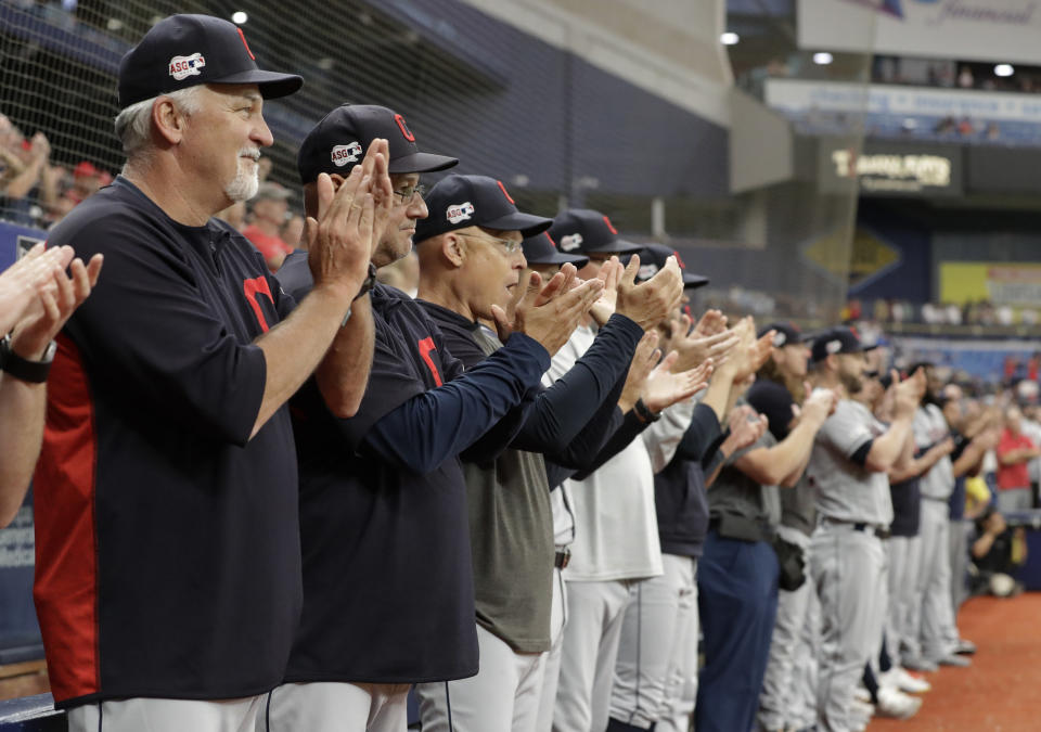 Cleveland Indians players and coaches applaud as pitcher Carlos Carrasco warms up during the seventh inning of a baseball game against the Tampa Bay Rays, Sunday, Sept. 1, 2019, in St. Petersburg, Fla. Carrasco is making his first appearance since May, after being diagnosed with leukemia. (AP Photo/Chris O'Meara)