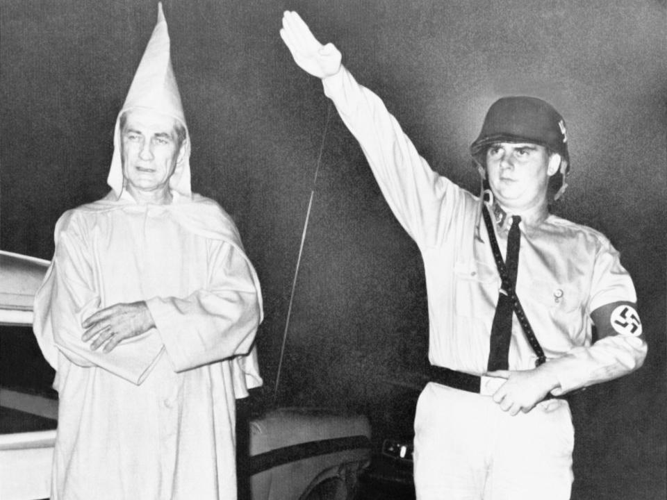 Clarence Brandenburg, 48, who says he's an officer in the Ku Klux Klan, left, and Richard Hanna, 21, admitted member of the American Nazi Party, pose for picture following their arrests, Aug. 8, 1964, Cincinnati, Ohio.