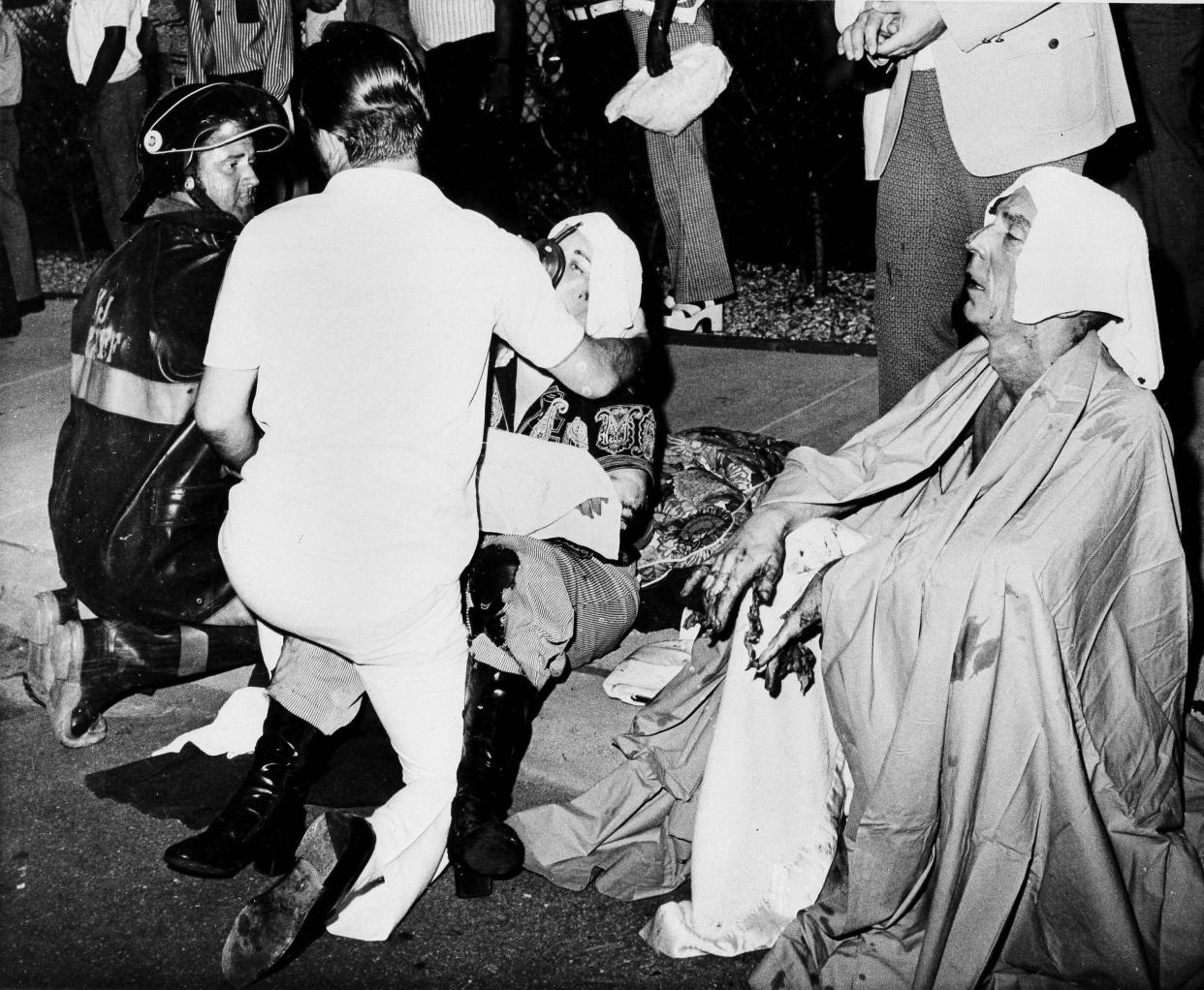 Firefighters give first aid to survivors of a French Quarter fire that swept through a second-floor bar, killing 29 and injuring 15, June 25, 1973, in New Orleans. 
