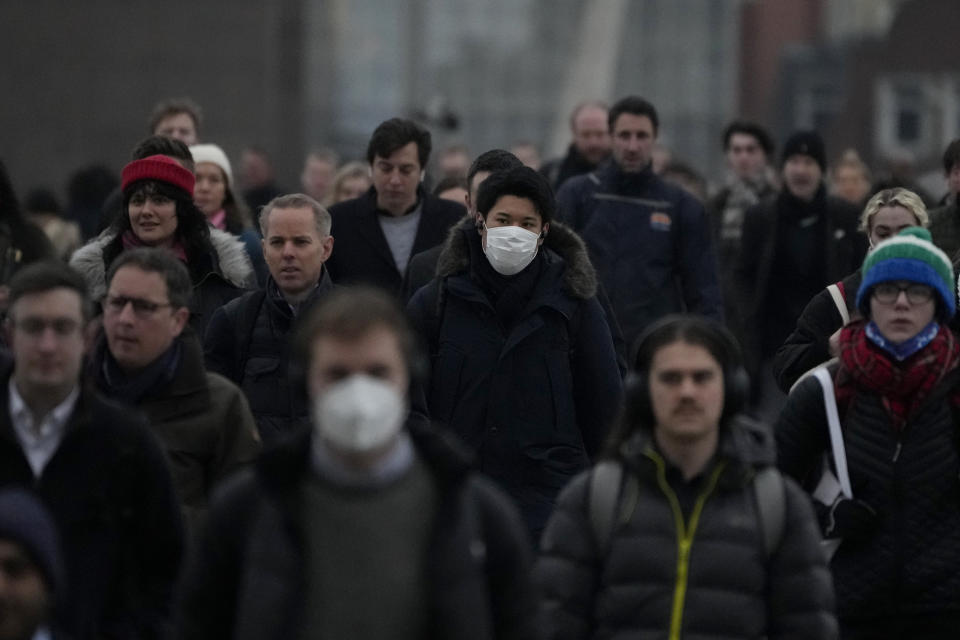 Workers walk over London Bridge towards the City of London financial district during the morning rush hour, in London, Monday, Jan. 24, 2022. The British government have asked people to return to working in offices starting Monday as they ease coronavirus restrictions. (AP Photo/Matt Dunham)