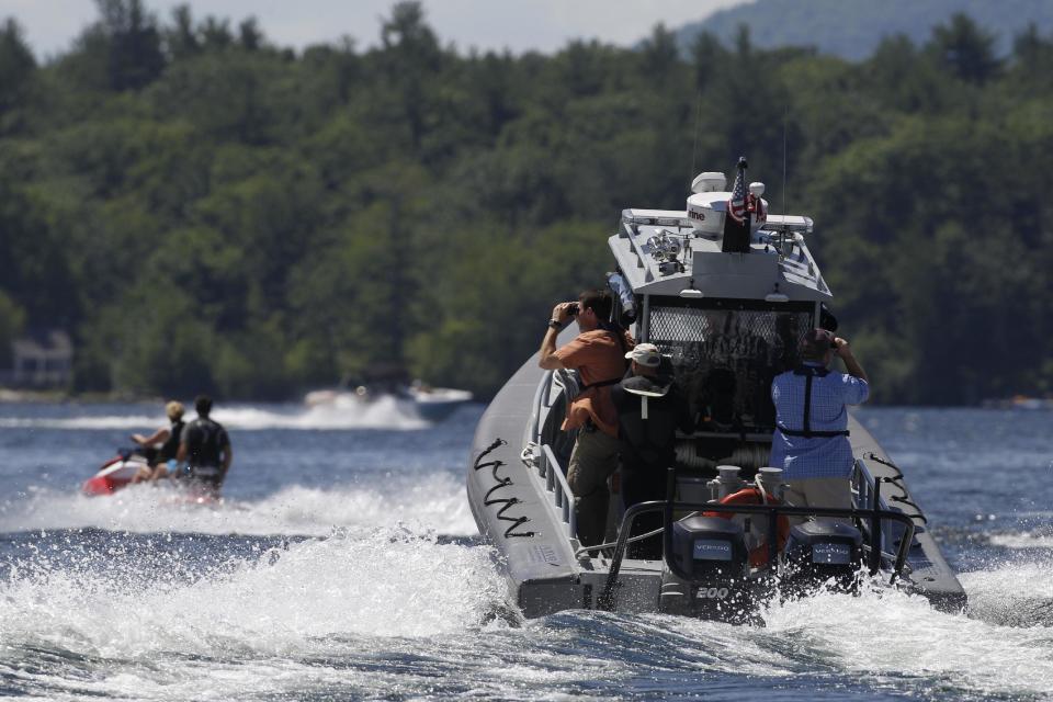 Security personnel follow Republican presidential candidate, former Massachusetts Gov. Mitt Romney and wife Ann Romney as they jet ski on Lake Winnipesaukee in Wolfeboro, N.H., Monday, July 2, 2012. (AP Photo/Charles Dharapak)