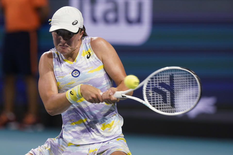 Iga Swiatek, of Poland, hits a backhand to Jessica Pegula during the Miami Open tennis tournament Thursday, March 31, 2022, in Miami Gardens, Fla. (AP Photo/Marta Lavandier)