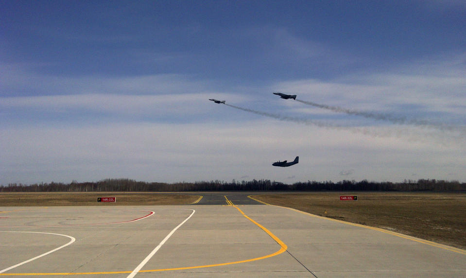 This Wednesday March 28, 2012 photo shows two German F-4 fighter jets escorting a Lithuanian C-27J Spartan transport plane, bottom, back to Siauliai Aribase airbase in Lithuania. The Spartan had simulated losing communications as it neared Finnish airspace as part of a NATO exercise. NATO hopes that international cooperation, with different member countries providing different capabilities, will save money in a time of austerity while building a full NATO-wide defense capability. (AP Photo/Don Melvin)