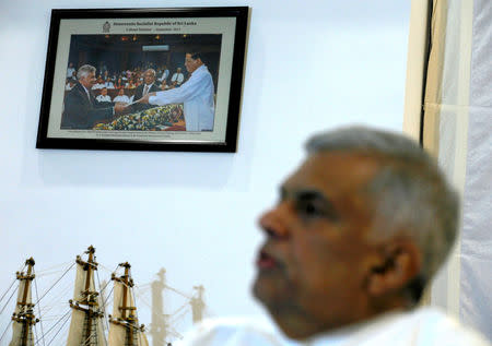 A photograph of Sri Lanka's ousted Prime Minister Ranil Wickremesinghe taking an oath as he was sworn in before President Maithripala Sirisena in 2015, is seen on a wall as Wickremesinghe speaks during an interview with Reuters at the Prime Minister's official residence in Colombo, Sri Lanka November 3, 2018. Picture taken November 3,2018. REUTERS/Dinuka Liyanawatte