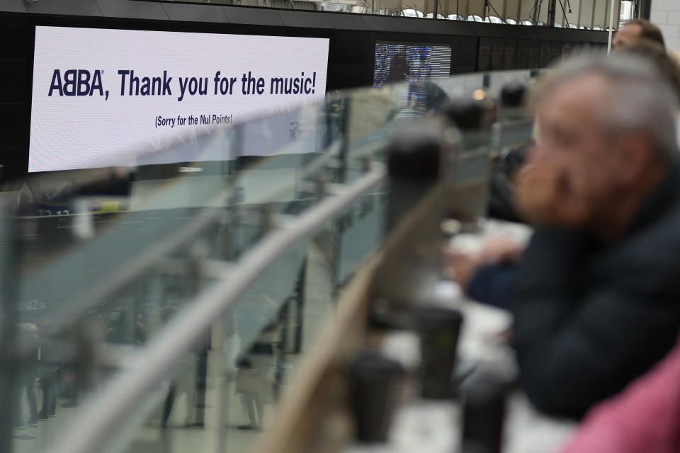 Members of the public watch a performance by the Mark de Lisser singers of the iconic ABBA song 'Waterloo' at Waterloo Station in London, Saturday, April 6, 2024. Fans are celebrating 50 years since ABBA won its first big battle with “Waterloo.” A half century ago on Saturday, April 6, the Swedish quartet triumphed at the 1974 Eurovision Song Contest with the peppy love song. (AP Photo/Alastair Grant)