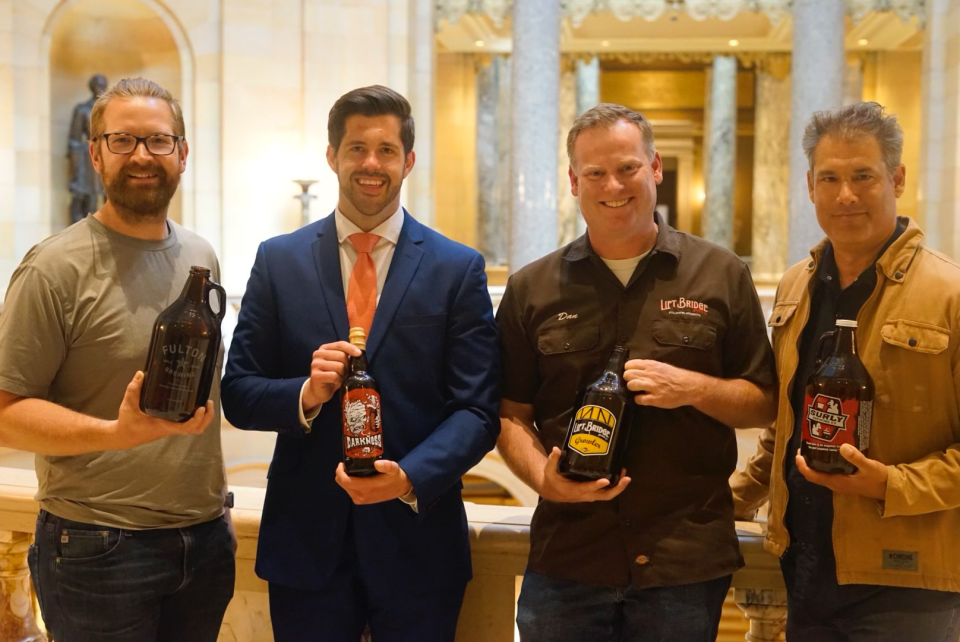 Jim Diley of Fulton Brewing, Rep. Dan Wolgamott, Dan Schwarz of Lift Bridge Brewing Company and Omar Ansari of Surly Brewing Company recognize the passing of the bill that raised the cap on what brewers could produce and still sell growlers from a taproom.