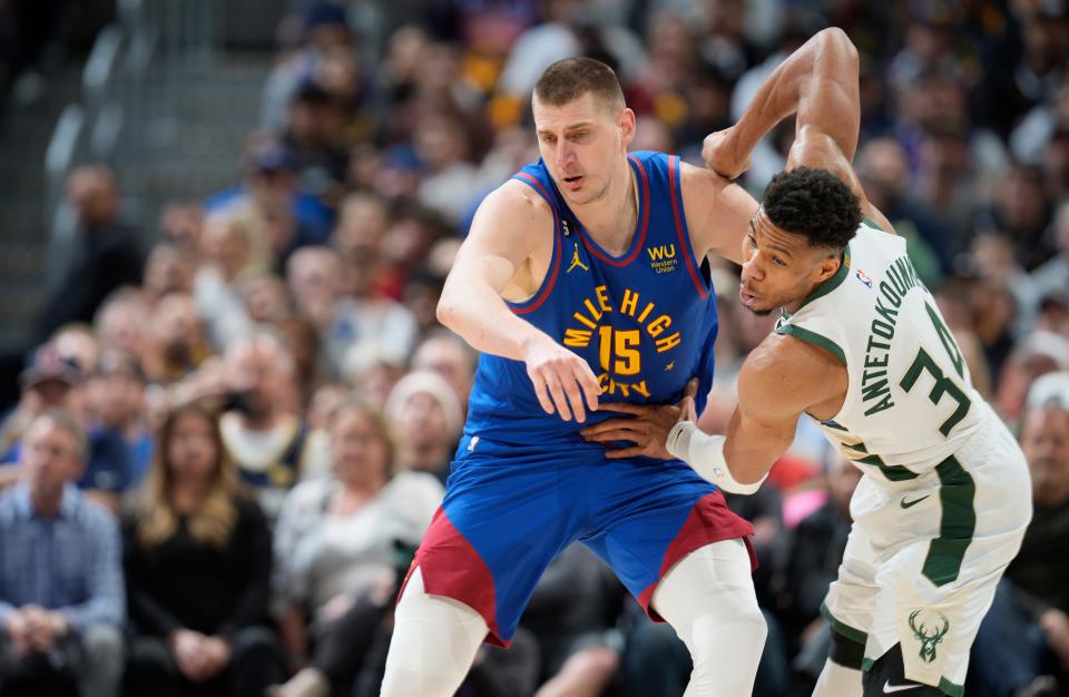 Bucks forward Giannis Antetokounmpo and Nuggets center Nikola Jokic jostle for poition during the second half aturday night.