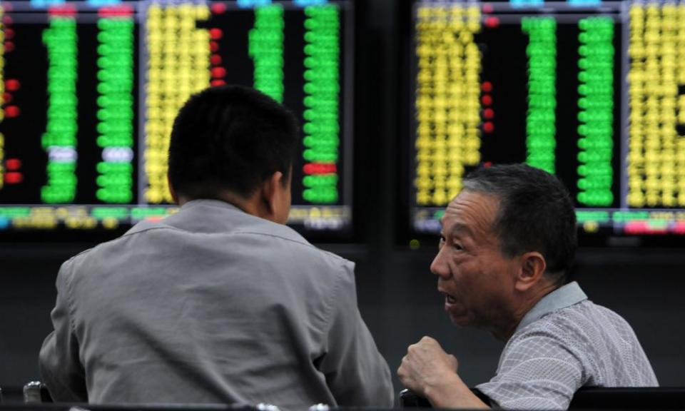 Investors monitor stock prices at a securities company in Jiujiang in China’s central Jiangxi province.