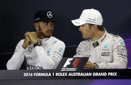 Mercedes F1 driver Nico Rosberg (R) speaks with teammate Lewis Hamilton at the post-race press conference in Melbourne. Australia Grand Prix - Melbourne, Australia - 20/03/16. REUTERS/Brandon Malone