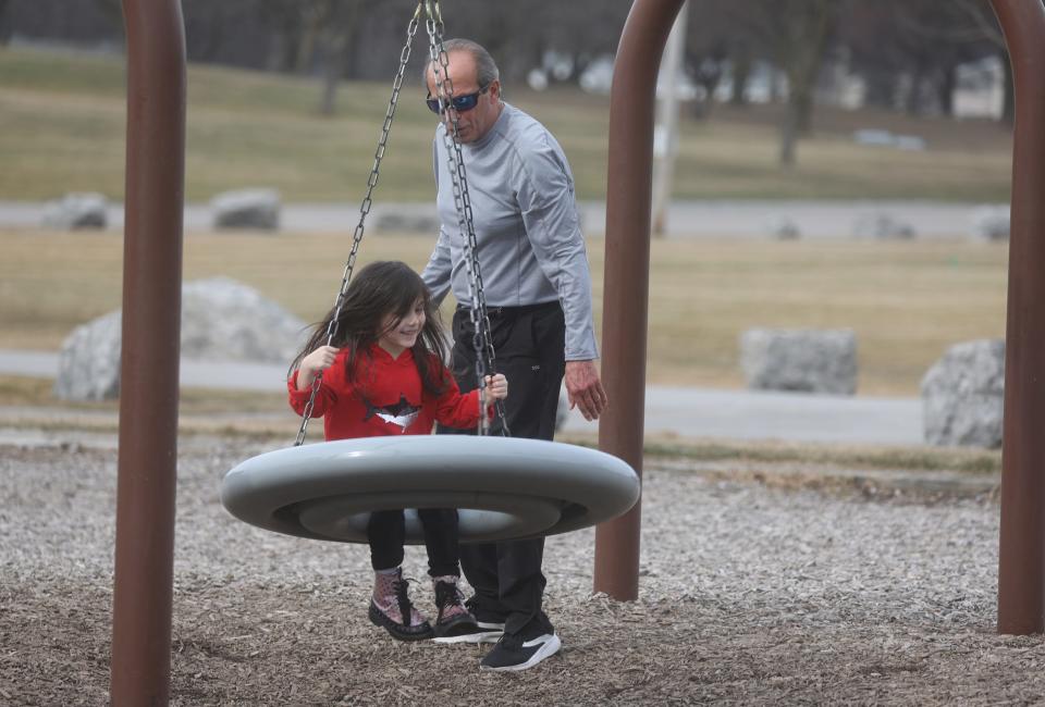 Lionel Rodriguez, of Geneseo, pushes his granddaughter, Ophelia Rodriguez, 1, of Henrietta on a spinning seat at Veterans Memorial Park in Henrietta, NY. Area residents got outside to enjoy the unseasonable warm weather. Today's temperature recorded at the Frederick Douglass Greater Rochester International Airport reached a high of 73 degrees at 1 p.m. breaking the previous record of 66 degrees that was set in 2000.