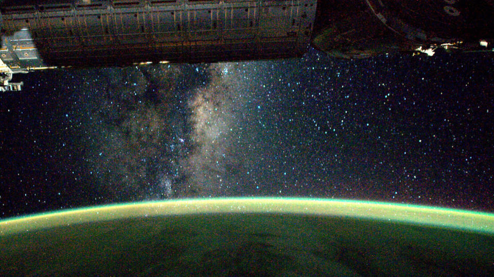 A photo of a green aurora with the Milky Way visible in the background