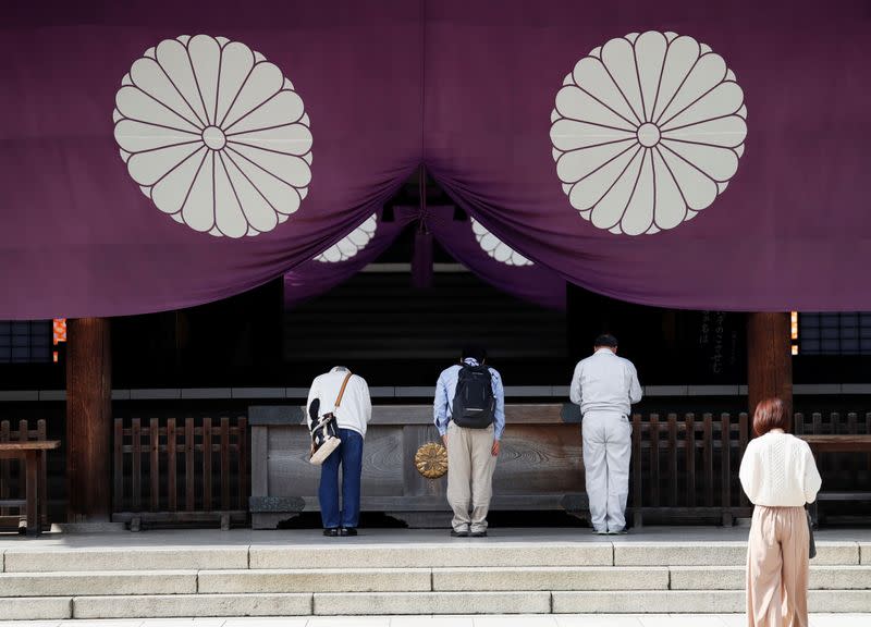 Visitors bow while paying tribute to the war dead during an autumn festival at Yasukuni Shrine in Tokyo