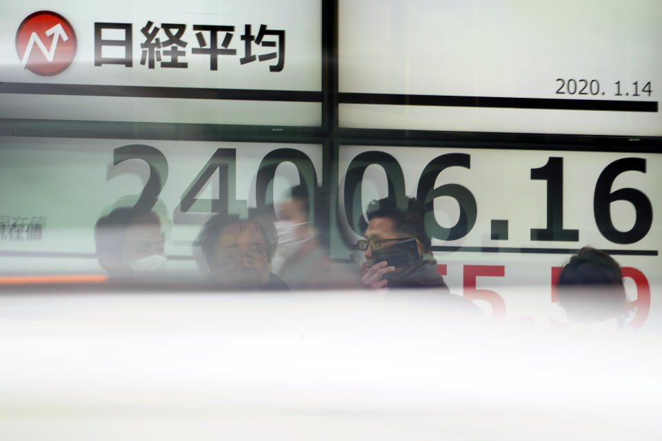 People stand in front of an electronic stock board showing Japan's Nikkei 225 index at a securities firm in Tokyo Tuesday, Jan. 14, 2020. Asian shares followed Wall Street higher on Tuesday amid optimism that a trade deal between the U.S. and China will be a boon for the regional economy. (AP Photo/Eugene Hoshiko)