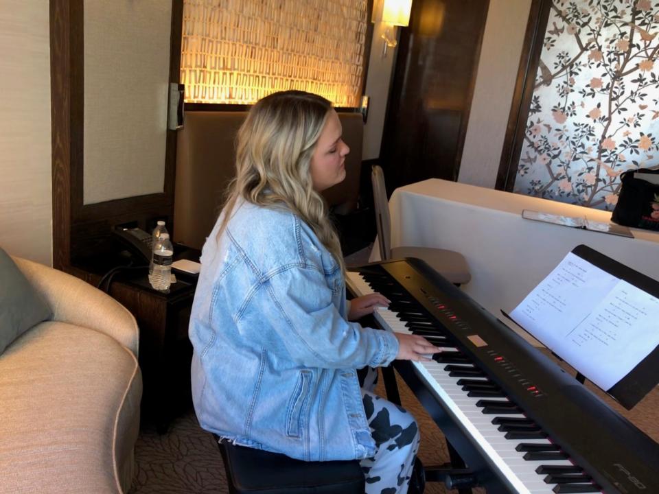 Faith Rhodes plays the piano.