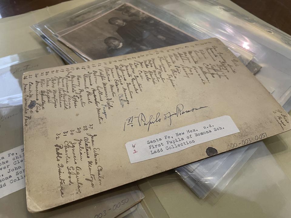 This July 8, 2021 image of material archived at the Center for Southwest Research at the University of New Mexico in Albuquerque, New Mexico, shows a list of names of Indigenous students who attended the Ramona Industrial School in Santa Fe. Many of the late 19th century photographs that make up the Horatio Oliver Ladd Photograph Collection are related to the boarding school. (AP Photo/Susan Montoya Bryan)