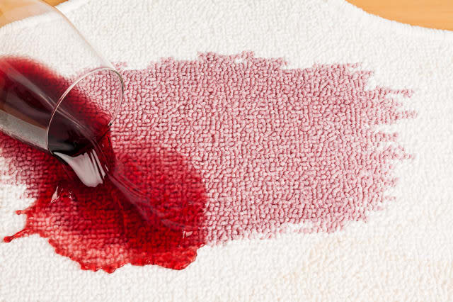 red wine is spilled on a carpet....