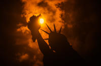 <p>The solar eclipse is seen behind the Statue of Liberty at Liberty Island in on Aug. 21, 2017 in New York City. (Photo: Noam Galai/WireImage) </p>