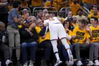 New York Knicks guard Jalen Brunson (11) falls into fans while trying to save a loose ball during the second half of Game 3 against the Indiana Pacers in an NBA basketball second-round playoff series, Friday, May 10, 2024, in Indianapolis. (AP Photo/Michael Conroy)