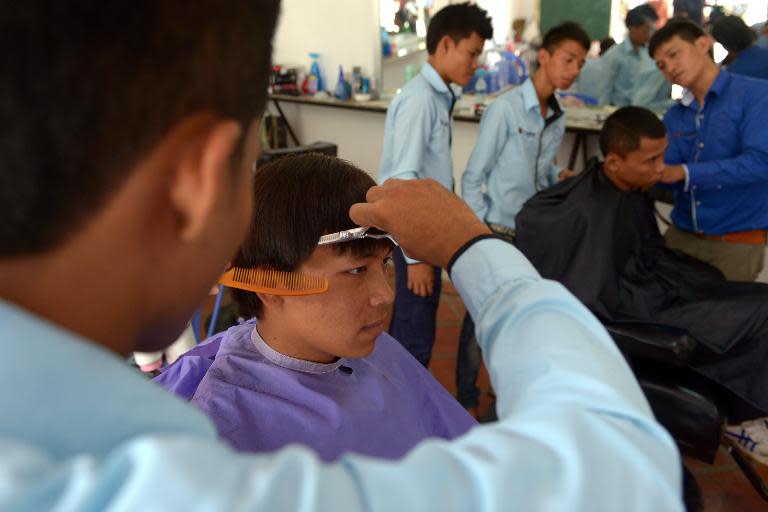 Deaf Cambodian students training at a hairdresser's shop in Phnom Penh, on October 15, 2013