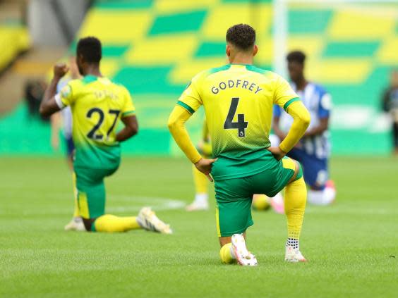 Norwich and Brighton players take a knee at the start of their Premier League match (AP)