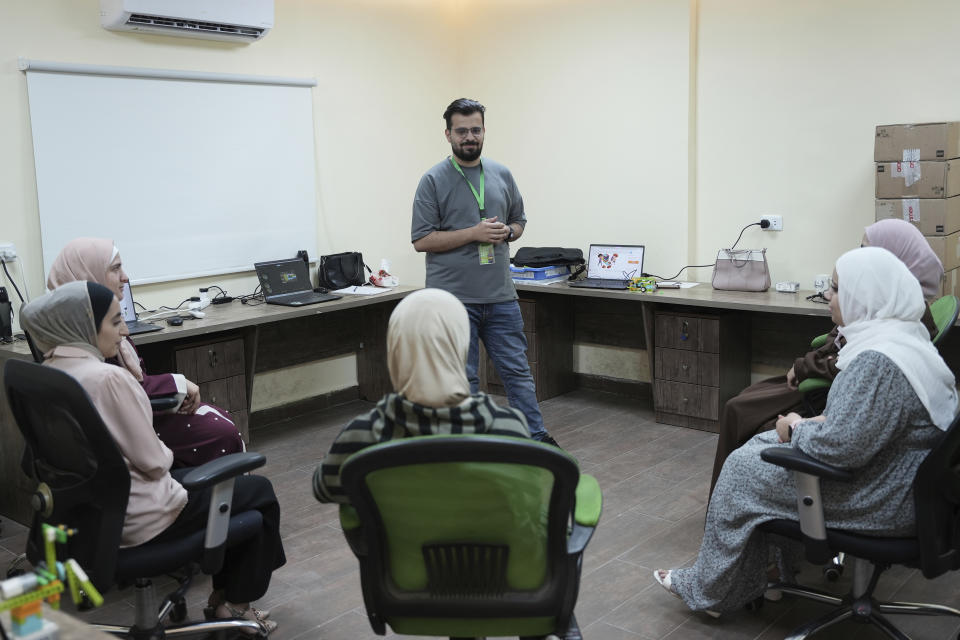 In this photo taken Tuesday, June 13, 2023, Jaser Alharasis, co-founder and CEO of a start-up that trains young Jordanians in robotics and artificial intelligence called Robotna, talk to his team in east Amman, Jordan. (AP Photo/Raad Adayleh)