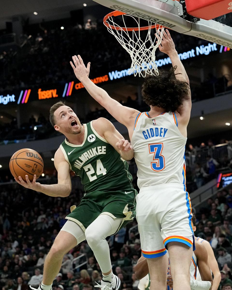 Milwaukee Bucks guard Pat Connaughton (24) scores on Oklahoma City Thunder guard Josh Giddey (3) during the first half of their game Sunday, March 24, 2024 at Fiserv Forum in Milwaukee, Wisconsin.