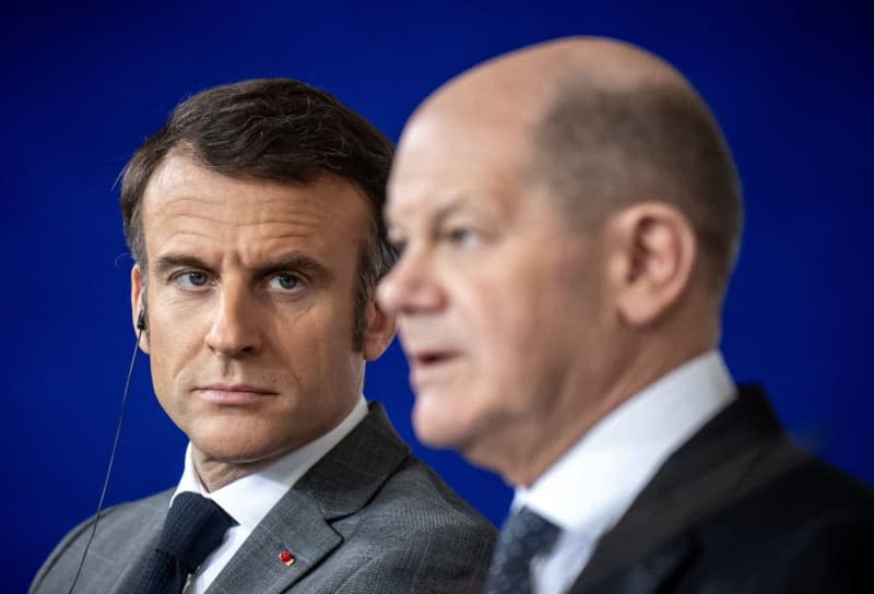 German Chancellor Olaf Scholz (R) and French President Emmanuel Macron speak during a press statement with Polish Prime Minister Donald Tusk (Not Pictured) after the so-called Weimar Triangle meeting. Michael Kappeler/dpa
