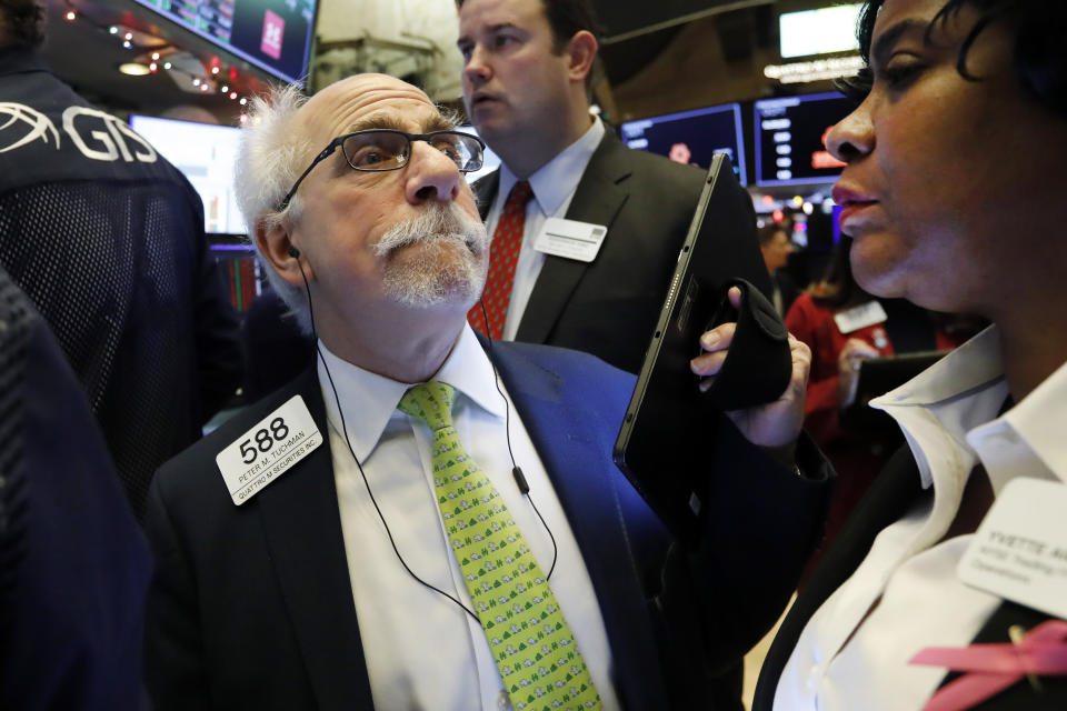 Trader Peter Tuchman left, works on the floor of the New York Stock Exchange, Friday, Dec. 13, 2019. After months of waiting, markets had a muted reaction to news Friday that the US and China had reached an initial deal on trade. (AP Photo/Richard Drew)