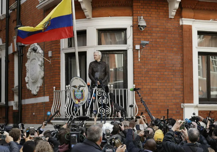 Watched by the media WikiLeaks founder Julian Assange looks out from the balcony of the Ecuadorian embassy prior to speaking, in London on May 19, 2017. (Matt Dunham/AP)