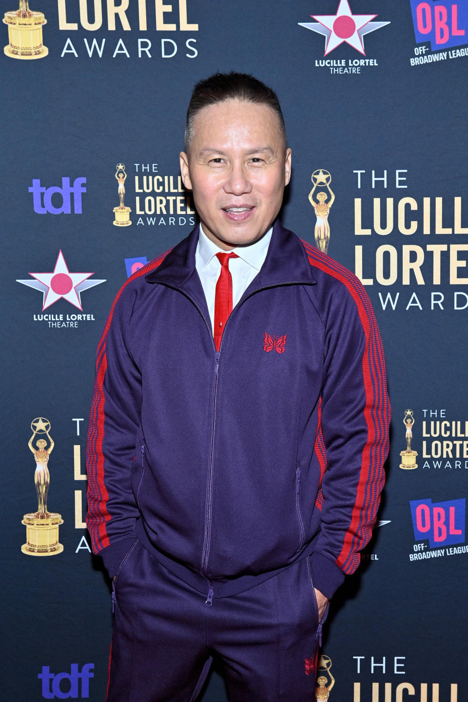 BD Wong at the Lucille Lortel Awards, wearing a matching tracksuit with a red tie