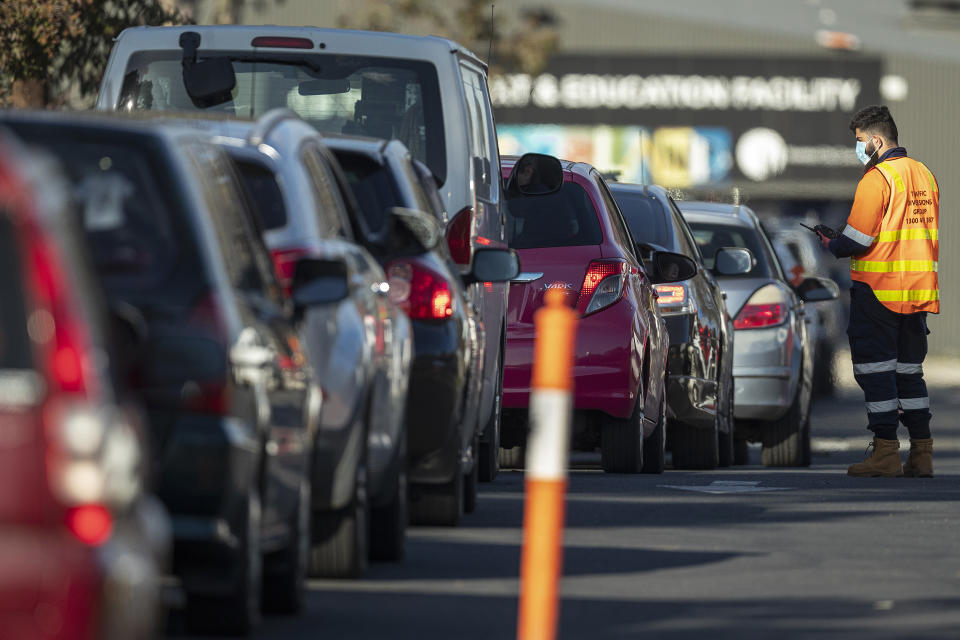 MELBOURNE, AUSTRALIA - JULY 01: Staff direct traffic in massive queues waiting to get into a pop-up COVID-19 test site in Fawkner on July 01, 2020 in Melbourne, Australia. Victorian premier Daniel Andrews on Tuesday announced lockdowns for residents of Melbourne suburbs identified as COVID-19 hotspots following a spike in new coronavirus cases through community transmission. From midnight Wednesday 1 July, residents of 10 postcodes will only be able to leave home have for exercise or work, to buy essential items including food or to access childcare and healthcare. The restrictions will remain in place until at least 29 July. (Photo by Daniel Pockett/Getty Images)