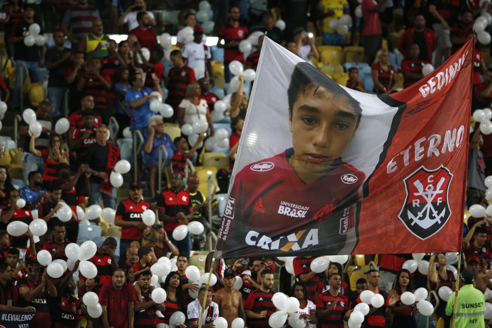 Fans hold a giant photo of Gedson Santos, a teenaged soccer player who was killed in a fire at the Flamengo training center last Friday, at Maracana Stadium in Rio de Janeiro, Brazil, Thursday, Feb. 14, 2019, ahead of a soccer match between Flamengo and Fluminense. (AP Photo/Leo Correa)