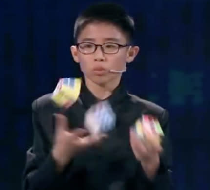 Que Jianyu set a Guinness World Record for the fastest time to solve three Rubik’s cubes while juggling. (Screenshot from Shanghaiist/Facebook)