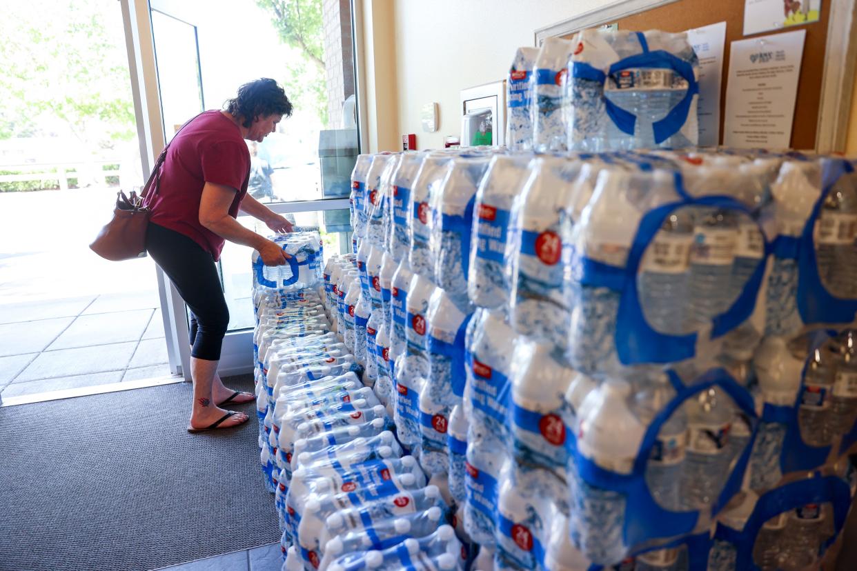 Martha Martinez picks up a case of water at Gervais City Hall on Tuesday. The city's water system was damaged during Saturday night’s storm and residents are under a 48-hour water-boil notice.