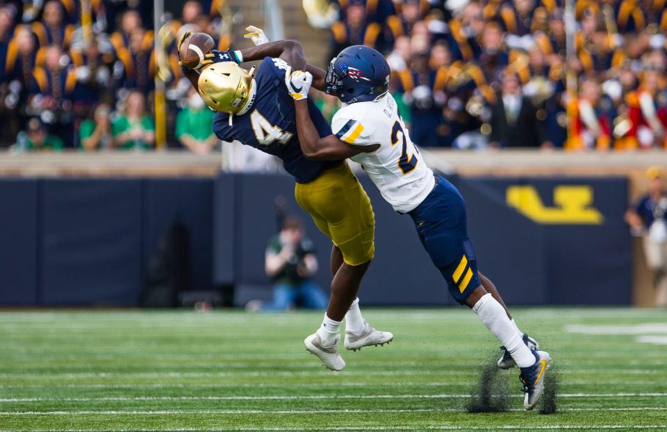 Notre Dame’s Kevin Austin Jr. (4) makes a catch as Toledo's Quinyon Mitchell (27) defends him during the Notre Dame vs. Toledo NCAA football game Saturday, Sept. 11, 2021 at Notre Dame Stadium in South Bend. 