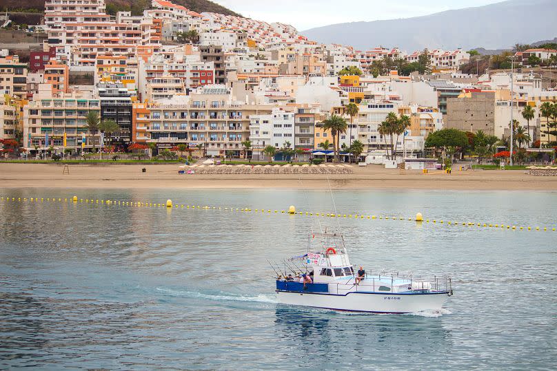 Un barco navega por delante de la playa de Los Cristianos, en la isla de Tenerife