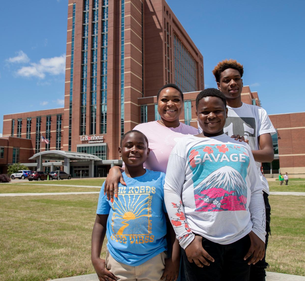 Anjelica Parker stands with her sons Khaidyn Parker, 8, Christopher Warmsley III, 11, and Donovan Coleman, 16, outside Le Bonheur Children's Hospital on May 6, 2022, in Memphis. Anjelica Parker works at the hospital after going through a local program that takes underemployed medical district residents and helps upskill them for jobs. 