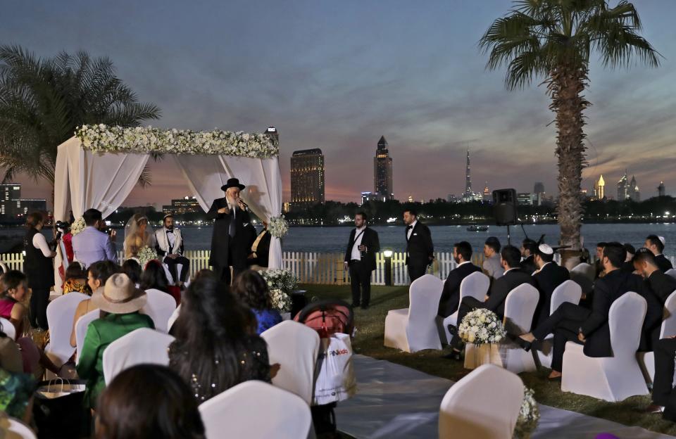 FILE, -A rabbi officiates under a traditional Jewish wedding canopy during marriage ceremony of the Israeli couple Noemie Azerad, left sited under the canopy, and Simon David Benhamou, at a hotel in Dubai, United Arab Emirates, Thursday, Dec. 17, 2020. When Israel struck an agreement to establish diplomatic ties with the United Arab Emirates in 2020, but two years after an expected windfall of Gulf Arab tourists to Israel has been little more than a trickle. (AP Photo/Kamran Jebreili, File)