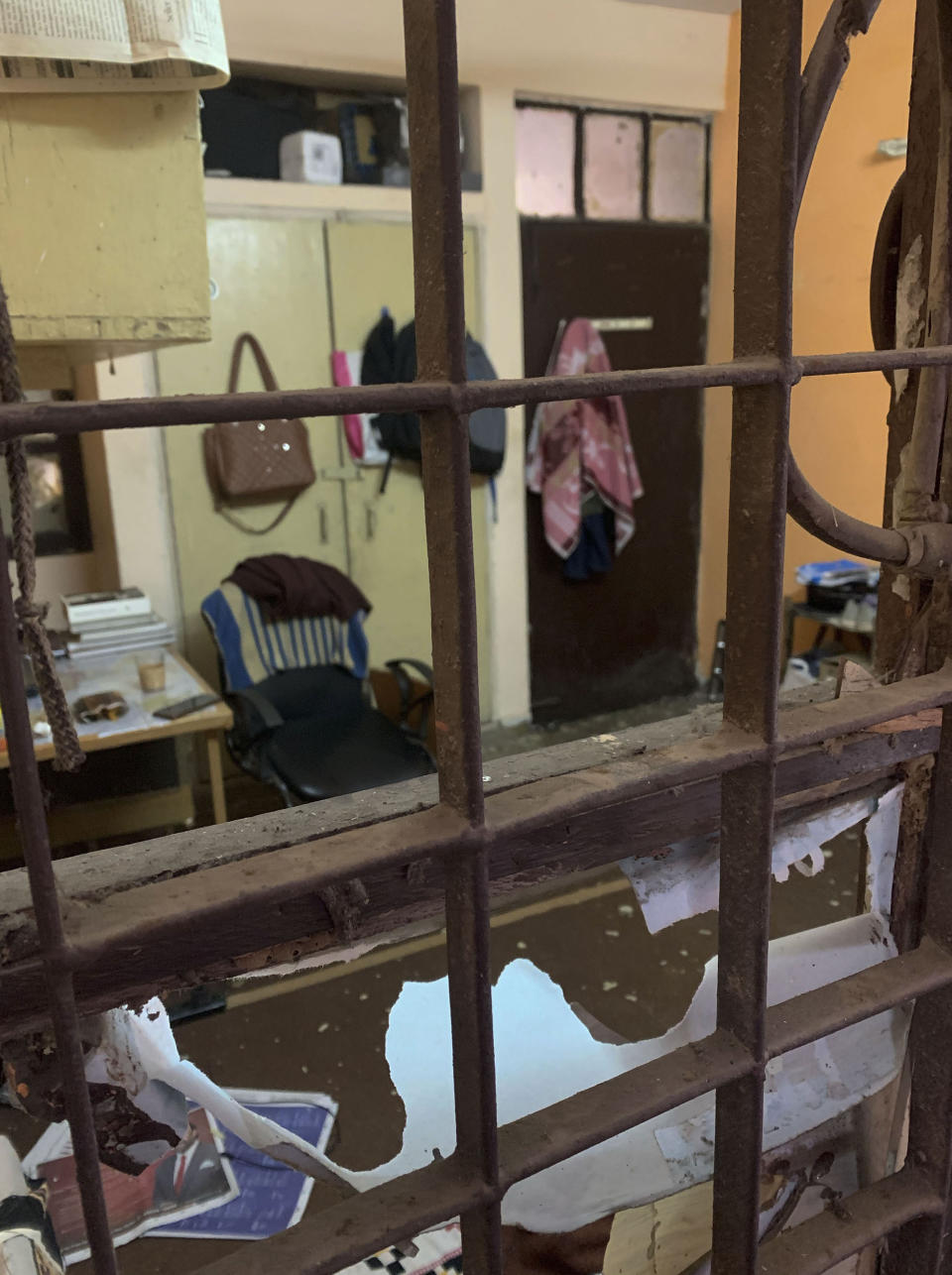 A portion of a student hostel building is seen through shattered glass after Sunday's assault by masked assailants at the Jawaharlal Nehru University in New Delhi, India, Monday, Jan. 6, 2020. More than 20 people were injured in the attack opposition lawmakers are trying to link to the government. (AP Photo/Emily Schmall)