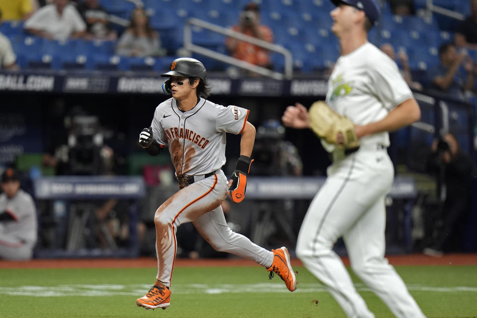 San Francisco Giants' Jung Hoo Lee, left, scores in front of Tampa Bay Rays pitcher Jacob Waguespack on a passed ball by catcher Ben Rortvedt during the third inning of a baseball game Friday, April 12, 2024, in St. Petersburg, Fla. (AP Photo/Chris O'Meara)