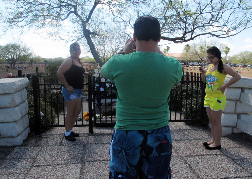 In this March 14, 2013 photo, tourists take photos in front of the the resting place of the late Tejano singer, Selena at the Seaside Memorial Park in Corpus Christi, Texas. The coastal Texas city's deep roots in Mexican American history is often overlooked as visitors mainly come here for a quick beach getaway. (AP Photo/Russell Contreras)