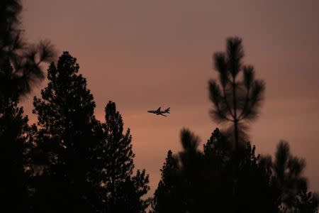 A DC10 firefighting air tanker flies over the King Fire in El Dorado National Forest northeast of Sacramento, California September 20, 2014. REUTERS/Stephen Lam