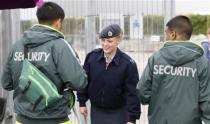 A member of the RAF checks the identifications of two G4S security guards at an exit to the Olympic Park in Stratford, the location of the London 2012 Olympic Games, in east London July 15, 2012. The head of private security firm G4S said on Saturday his firm only realised just over a week ago it would not be able to supply enough venue guards for this month's London Olympics, as he publicly apologised for the embarrassing failure. On Thursday, the government said it would deploy additional troops after it became clear G4S was unlikely to provide the expected 10,400 guards it was contracted to do because of problems processing applicants. REUTERS/Andrew Winning