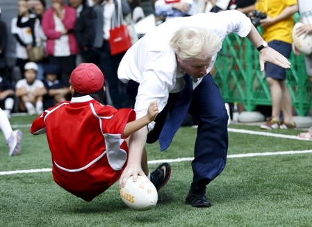 London's Mayor Boris Johnson collides with Toki Sekiguchi during a game of Street Rugby with in Tokyo