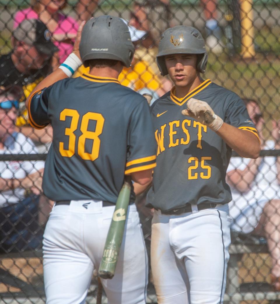 Central Bucks West's Kevin Bukowski (38) and teammate Alex Valdes celebrate the Bucks scoring a run during Tuesday's 14-1 District One playoff semifinal win over North Penn.