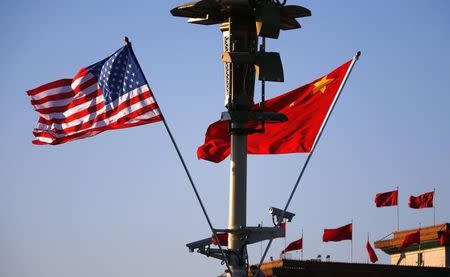 U.S. (L) and Chinese national flags flutter on a light post at the Tiananmen Square ahead of a welcoming ceremony for U.S. President Barack Obama, in Beijing, November 12, 2014. REUTERS/Petar Kujundzic