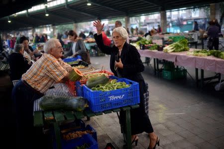A customer talks to a stallholder at the Monday market in the Basque town of Guernica, northern Spain, September 19, 2016. Picture taken September 19, 2016. REUTERS/Vincent West