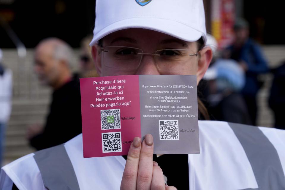 Una asistente muestra el código de acceso QR para entrar en Venecia ante la principal estación de tren de la ciudad, el jueves 25 de abril de 2024. Ante la mirada de los medios del mundo, la frágil ciudad ribereña de Venecia inició un programa piloto el jueves para cobrar una cuota de entrada de unos 5 euros (unos 5,35 dólares) a los que visiten el lugar sólo por un día. (AP Foto/Luca Bruno)